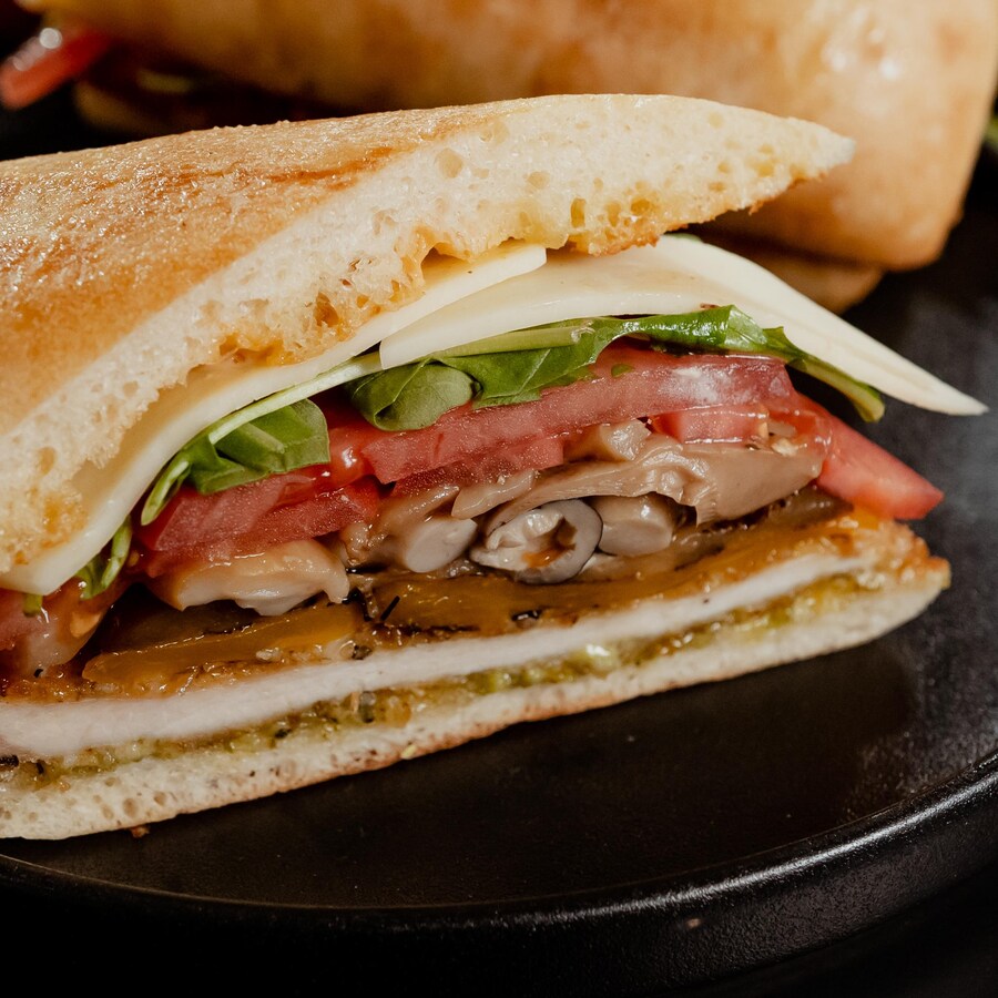 Un sandwich aux escalopes de poulet dans du pain ciabatta dans une assiette.