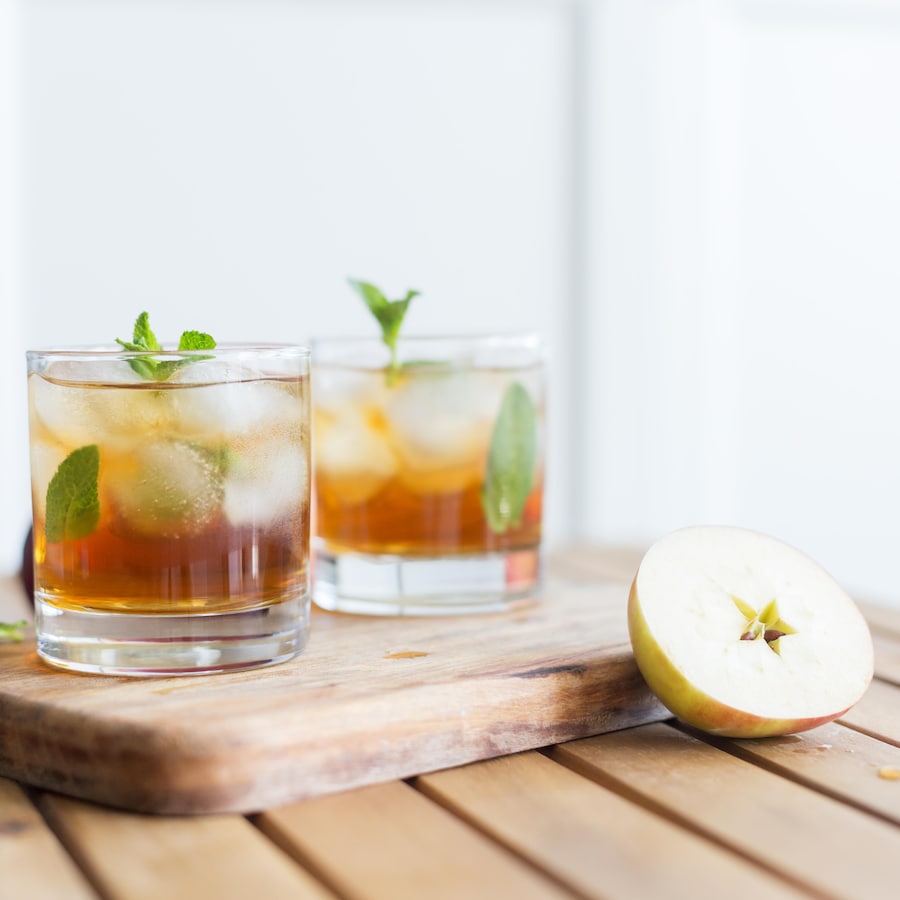 Deux verres remplis d'un cocktail à la pomme avec des feuilles de menthe.