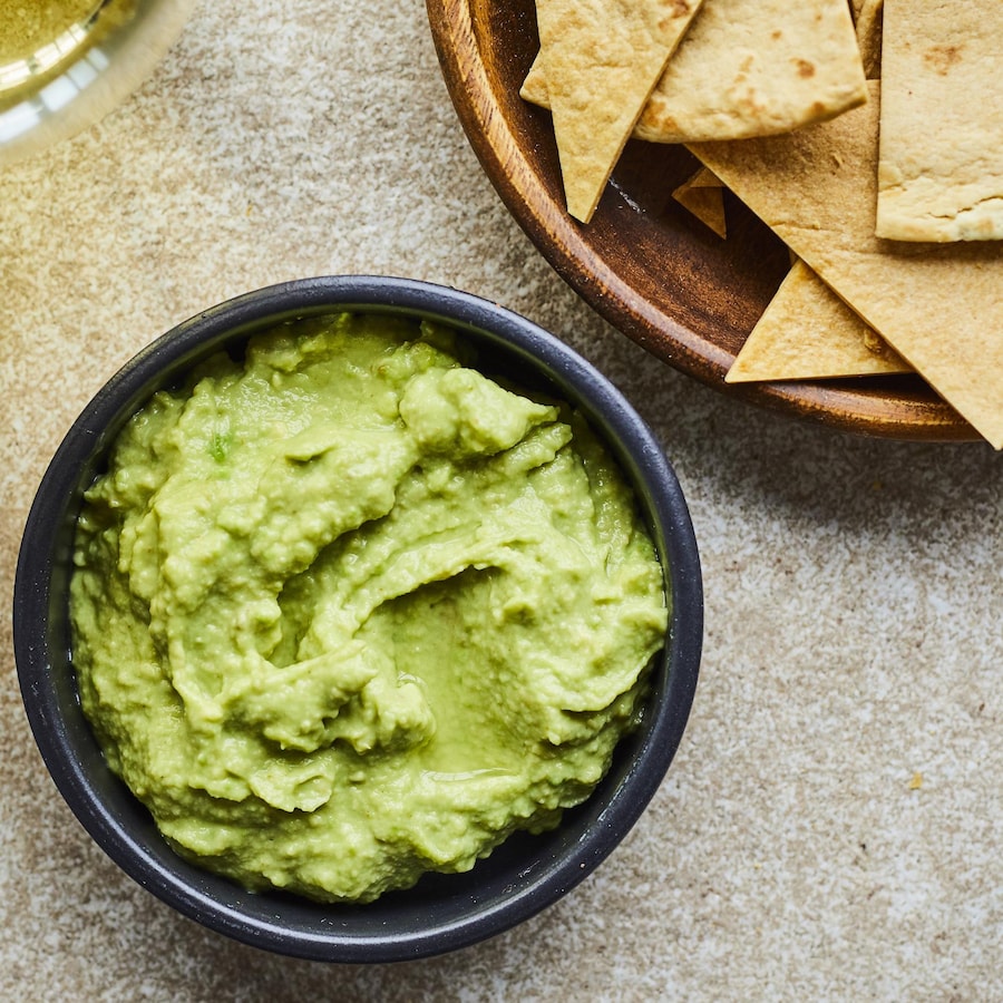 Un bol de tortillas avec un bol de guacamole. 