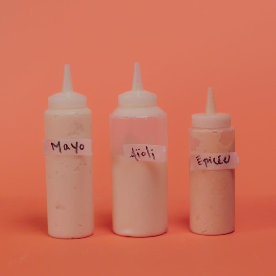 Trois pipettes remplies de mayonnaises différentes: classique, à l'ail (aïoli) et épicée.
