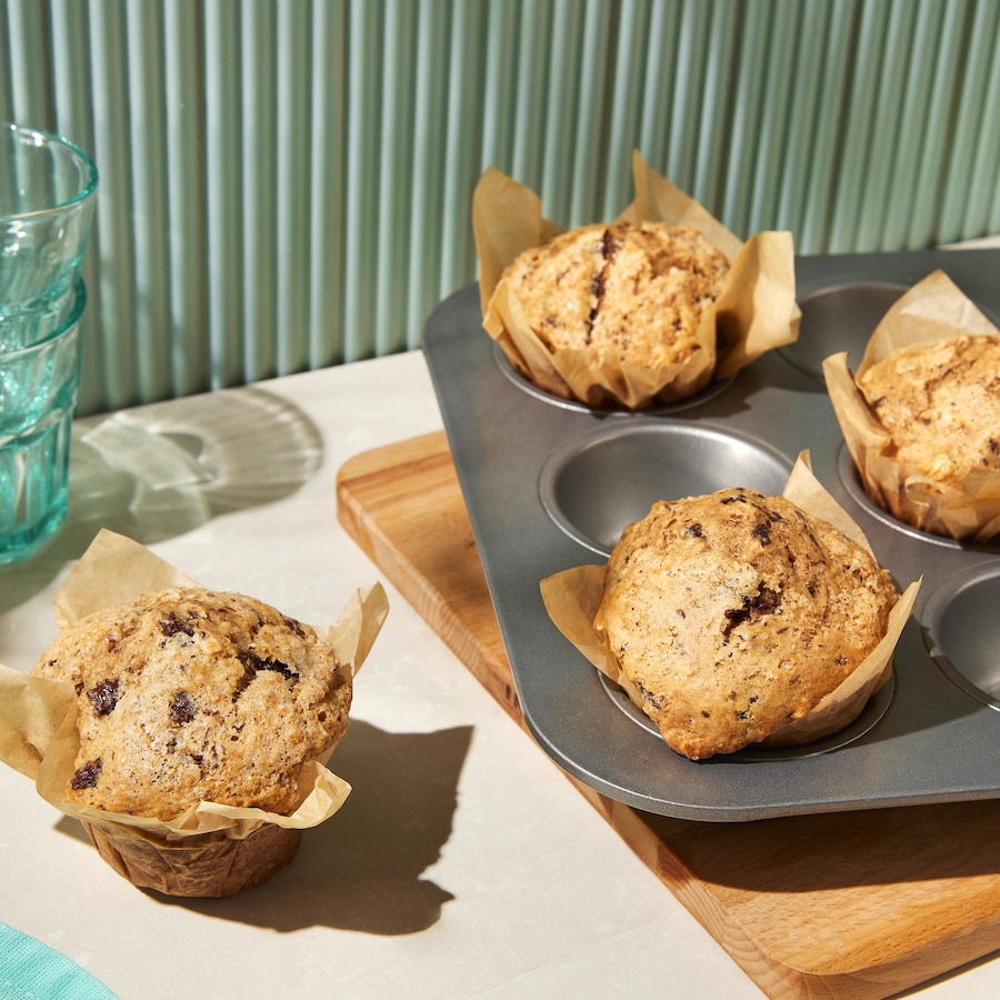 Des muffins végétaliens géants cannelle et morceaux de chocolat dans un moule.