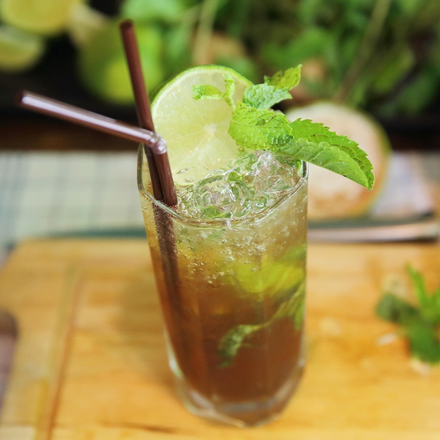 Un cocktail Papelón con limón au rhum dans un verre décoré de feuilles de menthe et d'une rondelle de lime..