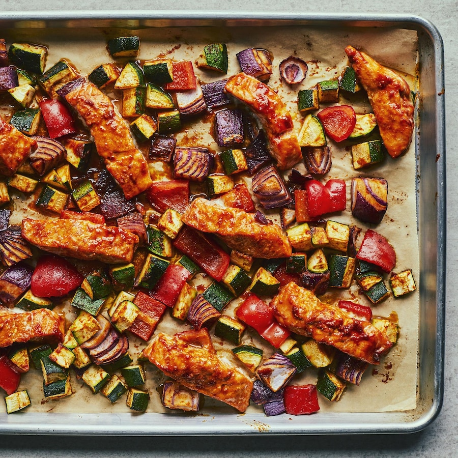 Une plaque de saumon cari-érable avec des légumes grillés sur un comptoir gris.