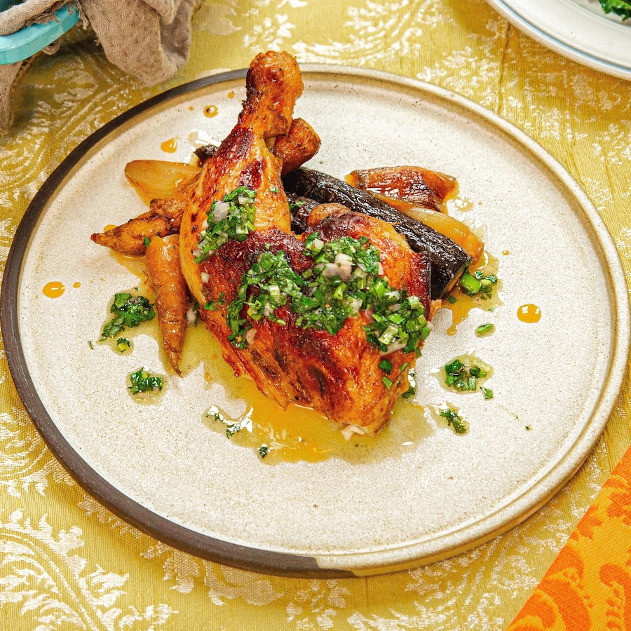 Une assiette avec une cuisse de poulet et des carottes glacées.