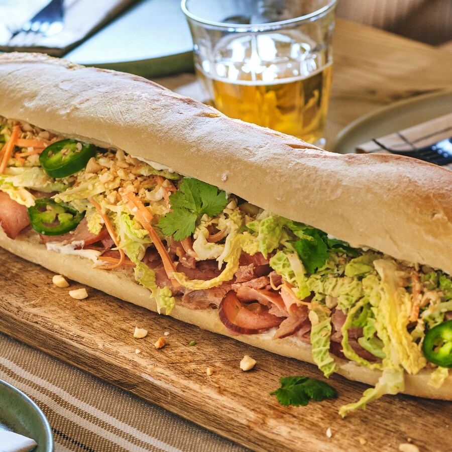 Un sandwich géant au jambon à l'érable sur une planche à découper.