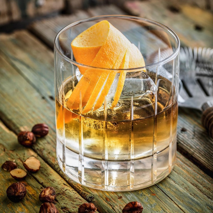 Un verre de scotch servi avec une écorce d'orange.