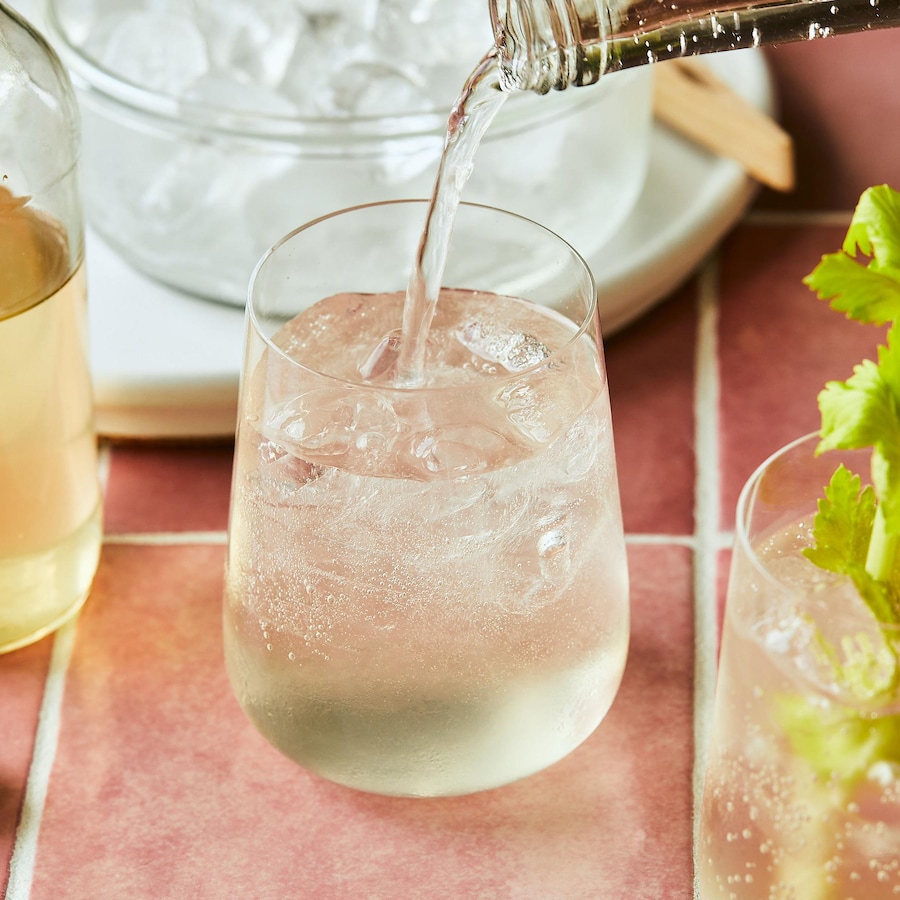 Trois verres de seltzer au thé du Labrador, avec un bol de glace, un verre de sirop et des branches de céleri. 