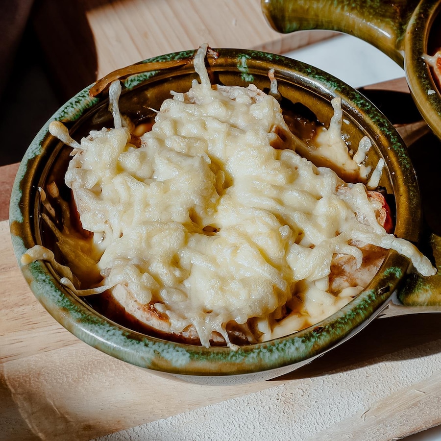 Deux bols de soupe à l'oignon gratinée avec une couche généreuse de fromage.