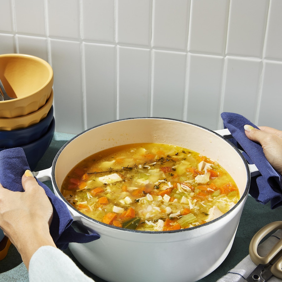 Une casserole contenant de la soupe poulet et riz.