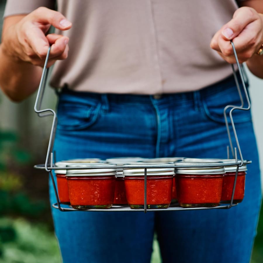 Sriracha maison dans de petits pots. Ceux-ci sont insérés dans un panier.