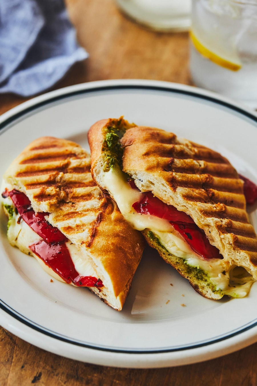 Dans une assiette, un panini à l'italienne tranché au milieu. 