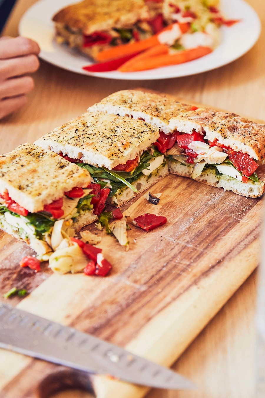 Gros sandwich à partager posé sur une planche de bois.