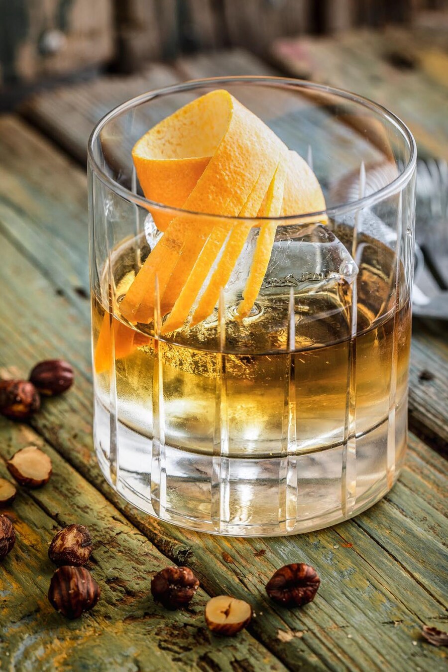 Un verre de scotch servi avec une écorce d'orange.