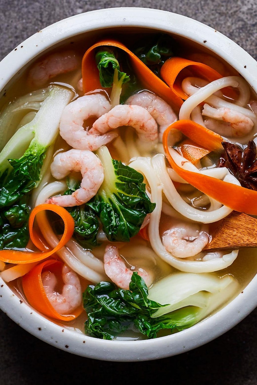 Soupe asiatique aux nouilles udon et aux crevettes nordiques dans un bol.
