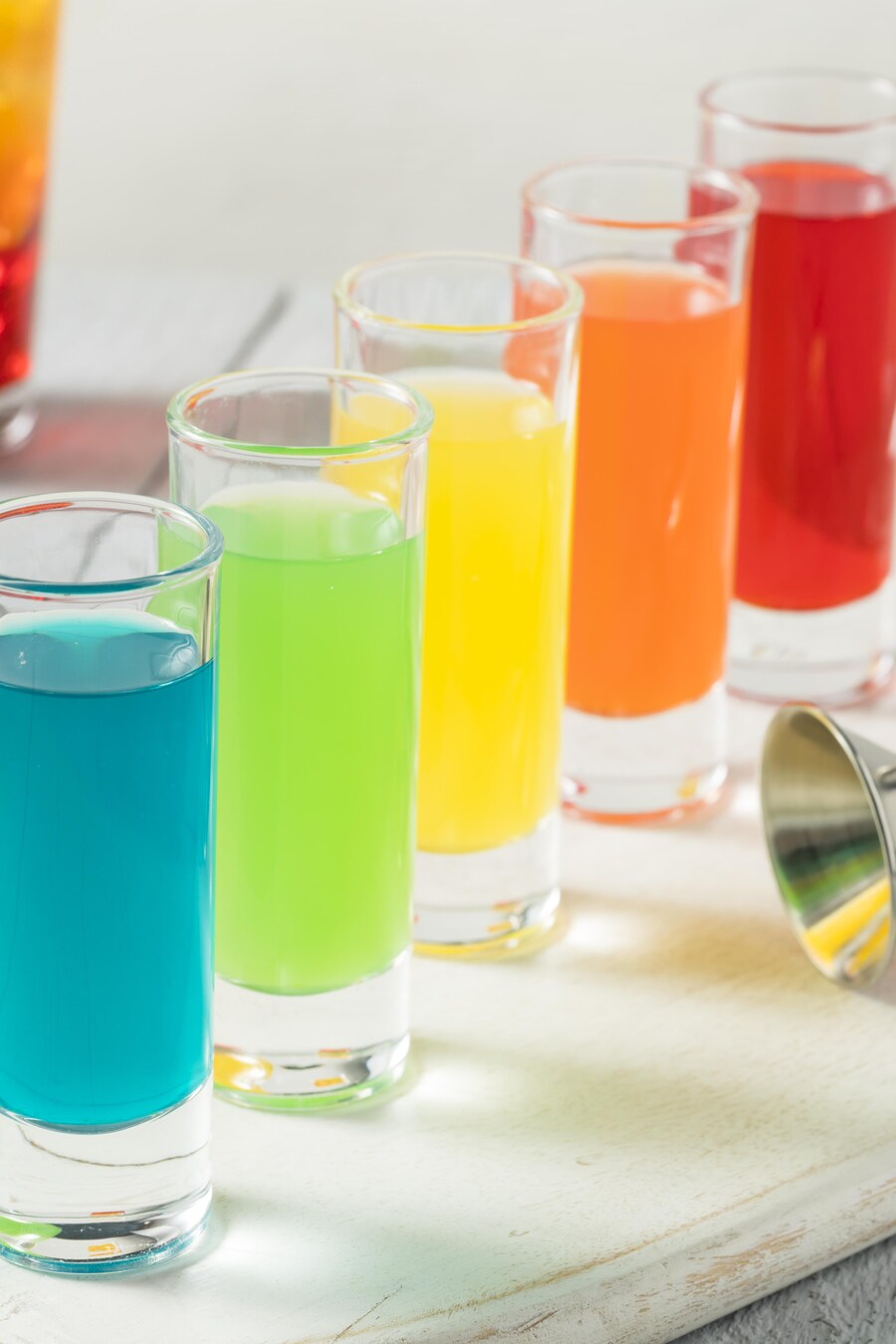 Des verres à shooter remplis de vodka Skittles de plusieurs couleurs.