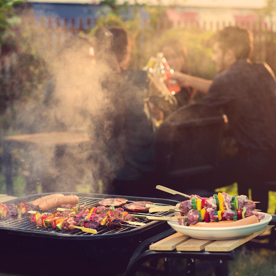 Des brochettes de viande et de légumes sur un barbecue pendant une fête.