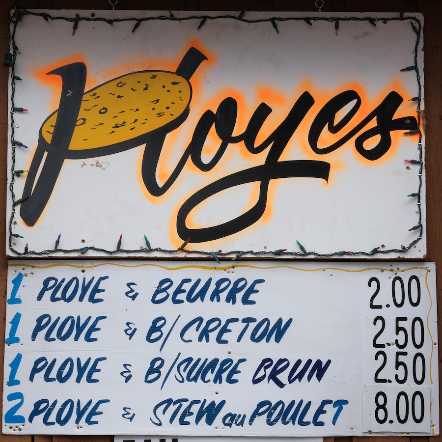 Le menu du restaurant Ployes écrit à la main sur une affiche à l'entrée.  