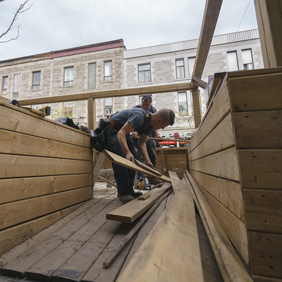Des ouvriers installent une terrasse près d'un restaurant de l'avenue du Mont-Royal.