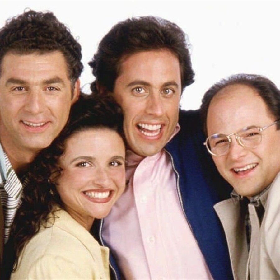 Michael Richards, Julia Louis-Dreyfus, Jerry Seinfeld et Jason Alexander posent, les uns contre les autres, sur un fond blanc.