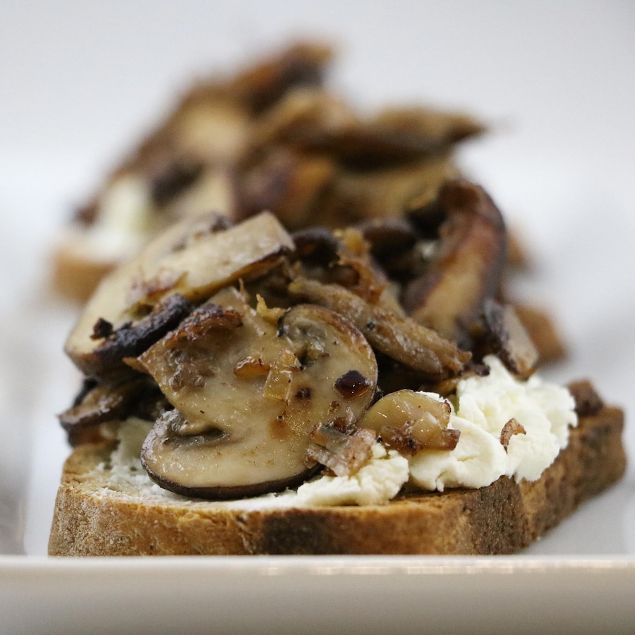 Des champignons sont déposés sur une tranche de pain.