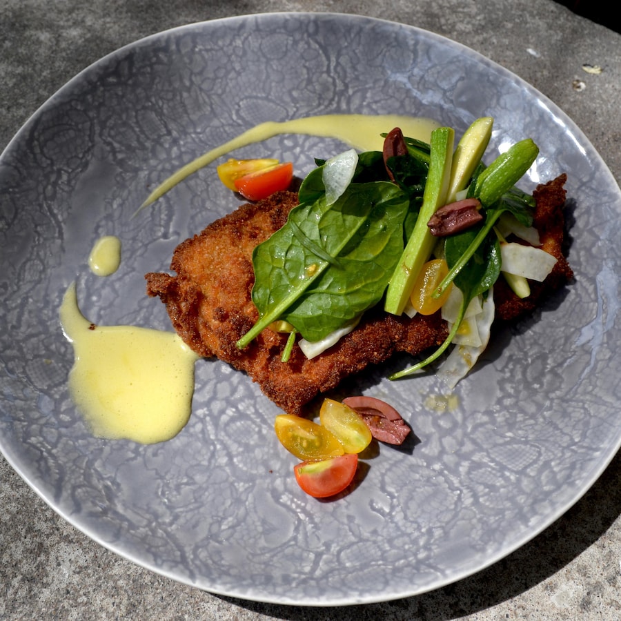 Une aile de raie panée servie avec une salade.