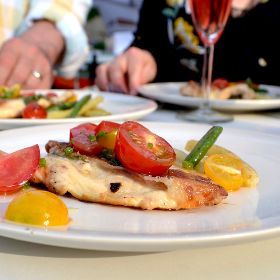 Des assiettes garnies d'une saltimbocca et d'une salade de légumes frais.