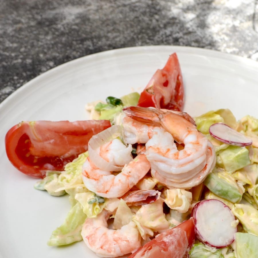 Salade estivale de crevettes présentée dans une assiette blanche.