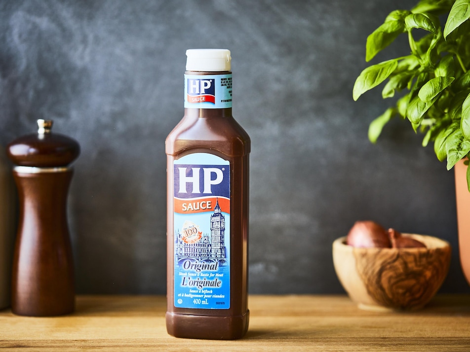 Sur une table, est déposé une bouteille de sauce à bifteck de type HP