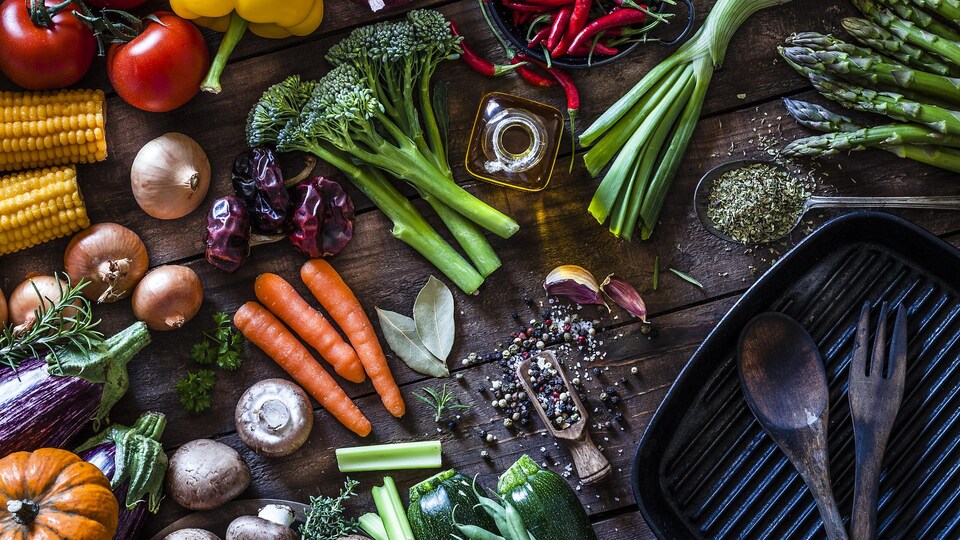 Vue de dessus d'une table en bois rustique remplie de légumes biologiques frais prêts pour la cuisson.
