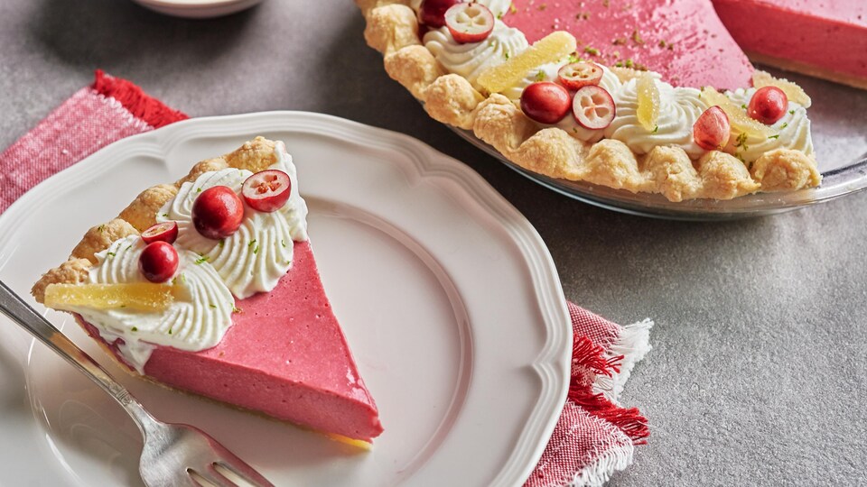 Une tarte aux canneberges et une part déjà coupée dans une assiette.