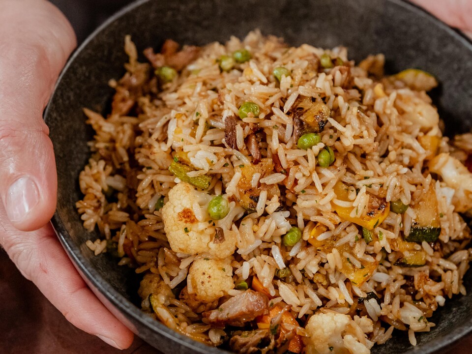 Un bol de riz frit vide-frigo, avec de la viande et des légumes.