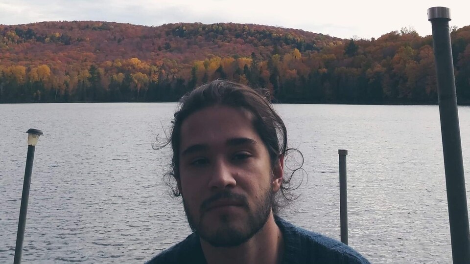 Michael Gouveia pose devant un lac et des montagnes.