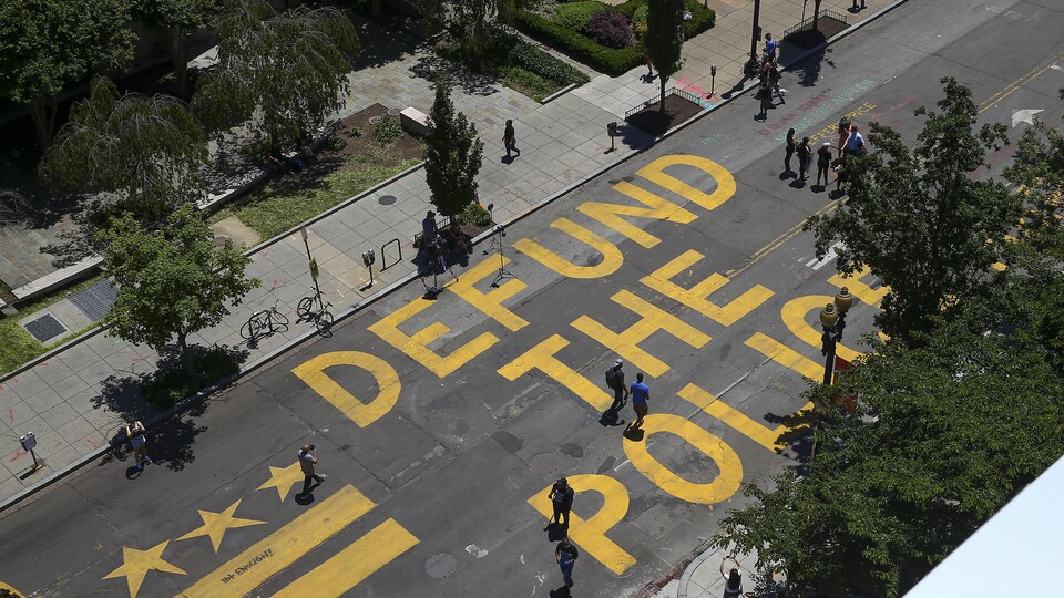 Les mots « Defund The Police » (Réduisez le budget de la police) peints sur une rue.