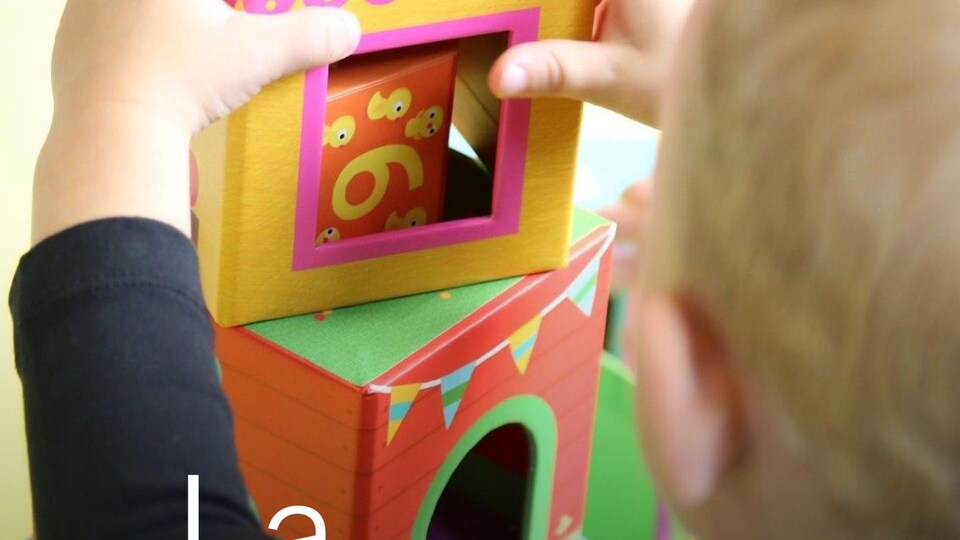 Un enfant de dos joue avec des blocs dans une garderie. 