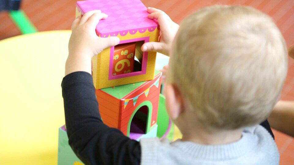 Un enfant de dos joue avec des blocs dans une garderie.