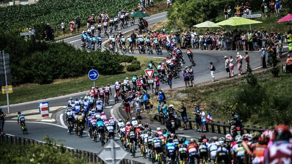 Le peloton des cyclistes négocie des virages durant le Tour de France.