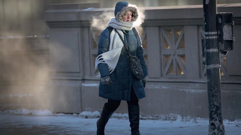 Une personne marche en ville dans le froid.