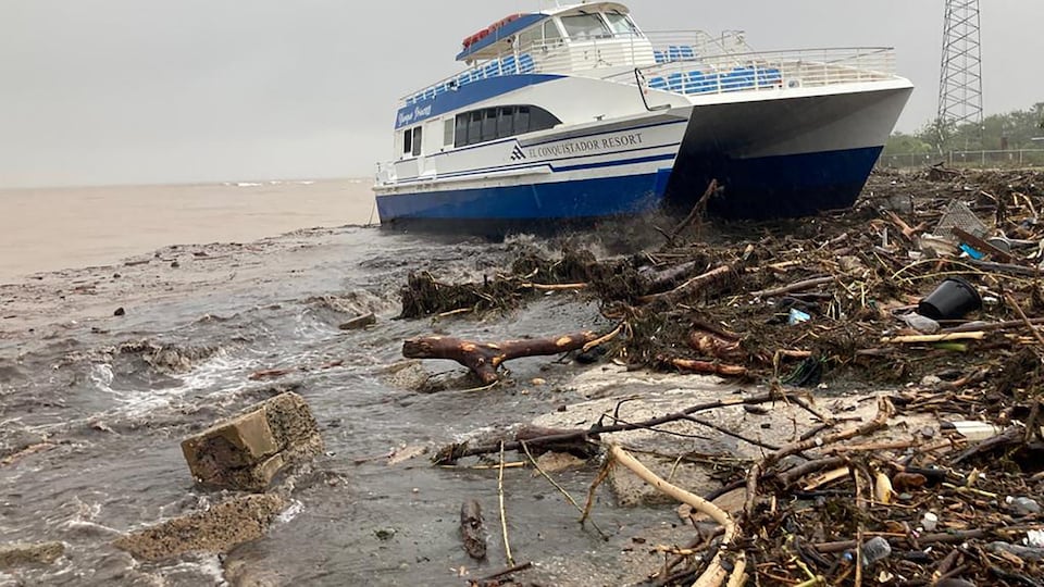 Un bateau est échoué sur une plage couverte de débris à Porto Rico.