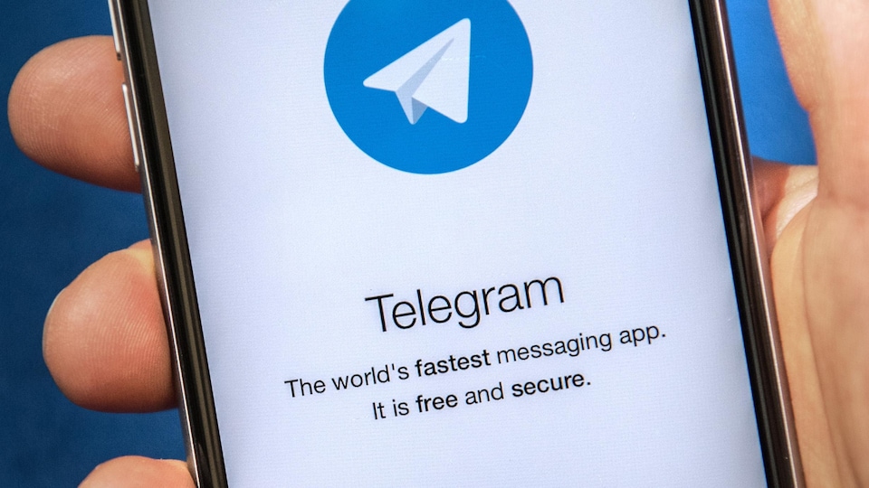On voit le logo de Telegram, qui est un avion de papier, sur l'écran d'un téléphone cellulaire.