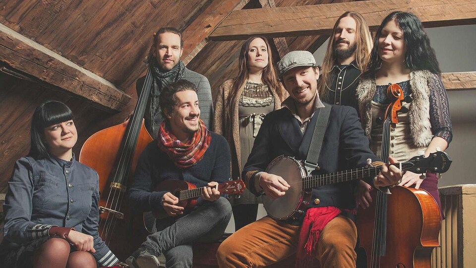 Les sept membres du groupe Bears of Legend sont assis avec leur intruments de musique