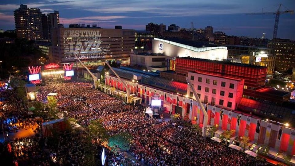 Vue aérienne d'une foule sur la place des Festivals, à Montréal, par un soir d'été.