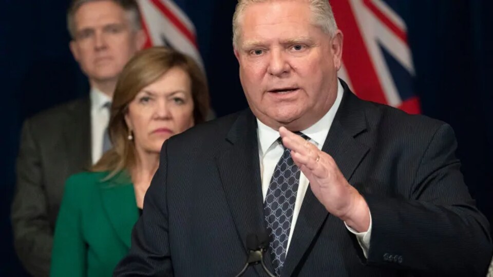 Le premier ministre de l'Ontario, Doug Ford, devant sa ministre de la Santé, Christine Elliott et son ministre des Soins de longue durée, Rod Phillips.