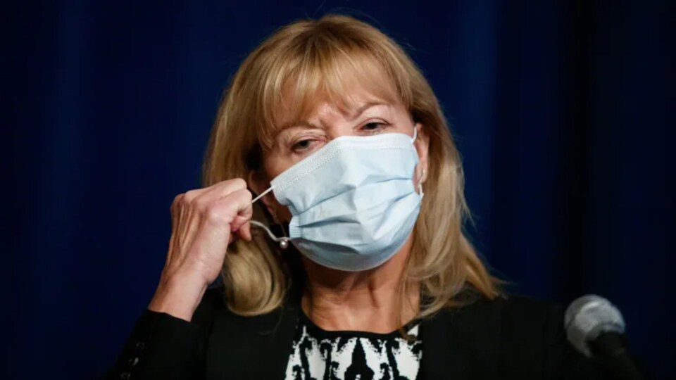 Minister Christine Elliott with a mask over her face.
