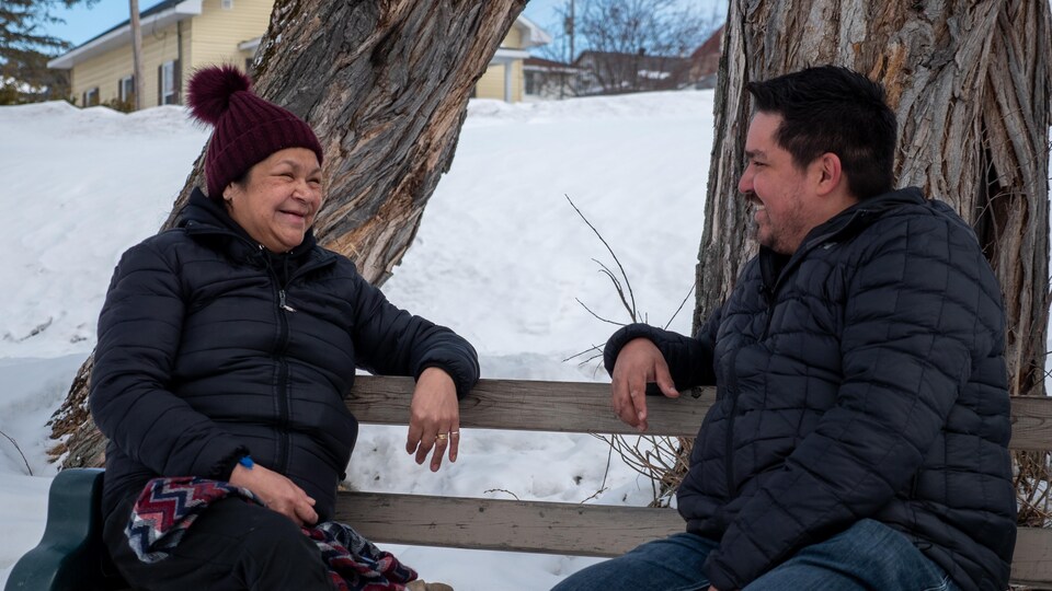Deux personnes discutent sur un banc.