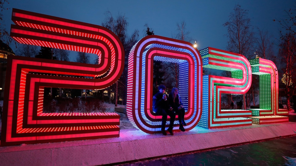 Des chiffres géants illuminés représentent l'année 2021 au parc Zaryadye, à Moscou, le 30 décembre 2020. Un couple est assis dans le zéro.