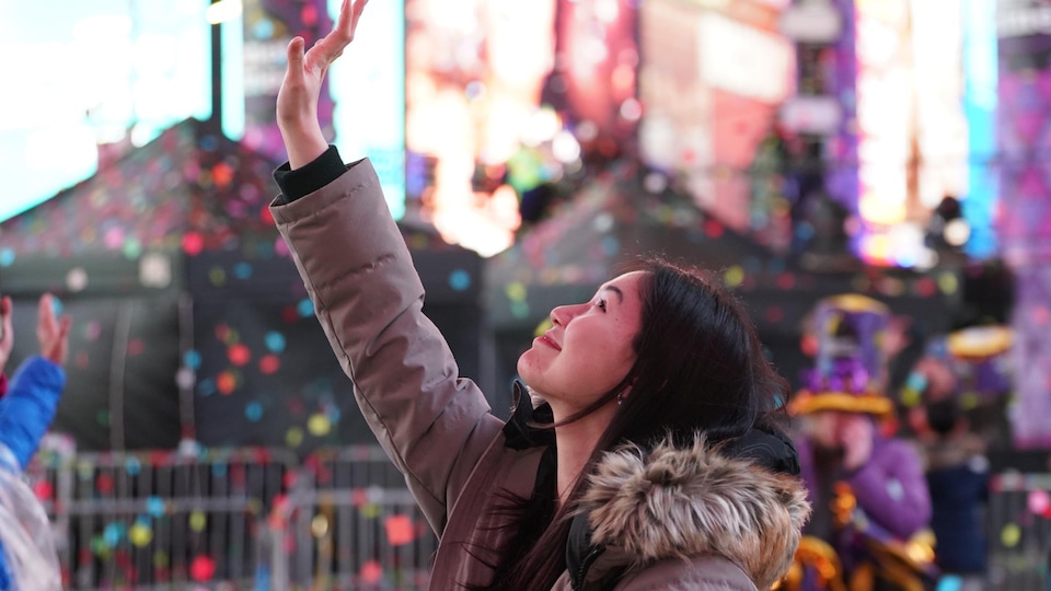 New York'ta bir kadın yeni yılı konfeti altında kutluyor.