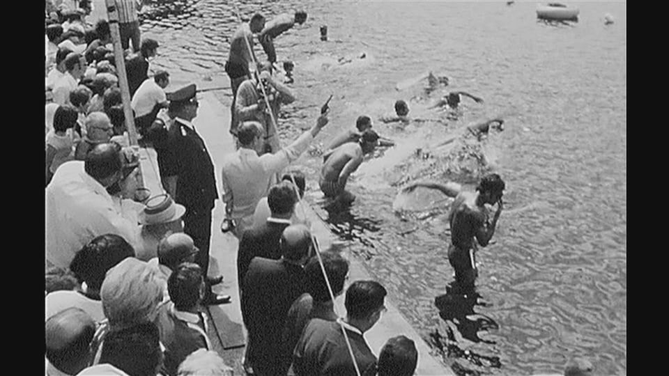 Une photo d'époque montrent des nageurs qui sautent à l'eau.