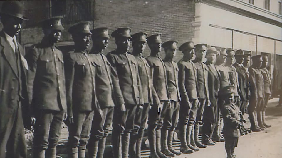 Des soldats au garde-à-vous, en uniforme, mais sans arme. 