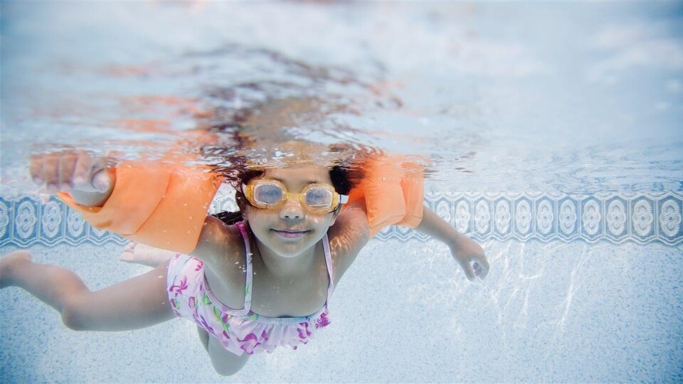 Une petite fille d'origine hispanique apprend à nager.
