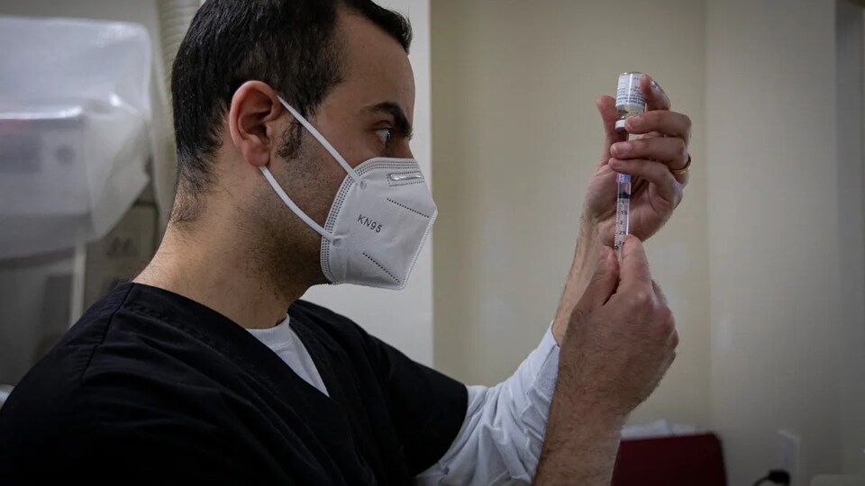 Maseh, seen here preparing a COVID-19 vaccine dose at his pharmacy in Toronto in April, said it felt 'sinful' to throw out expired COVID-19 vaccine doses.